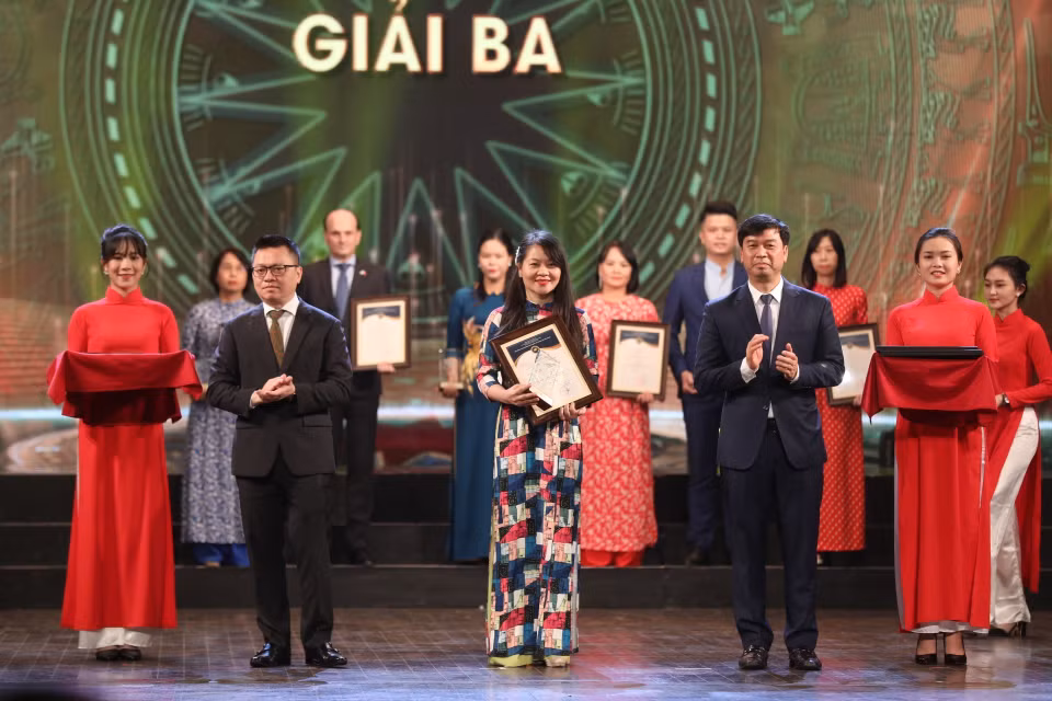 Ông Lê Quốc Minh, Tổng biên tập Báo Nhân dân và ông Ngô Minh Hiển, Phó Tổng giám đốc VOV trao giải Ba cho các tác giả, nhóm tác giả đoạt giải. (Ảnh: Minh Quyết/TTXVN)
