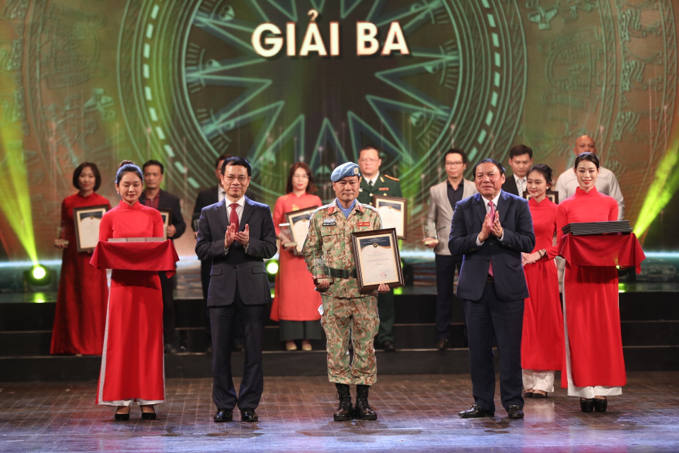 Bộ trưởng Bộ Thông tin và Truyền thông Nguyễn Mạnh Hùng và Bộ trưởng Bộ Văn hóa, Thể thao và Du lịch Nguyễn Văn Hùng trao giải Ba cho các tác giả, nhóm tác giả đoạt giải. (Ảnh: Minh Quyết/TTXVN)