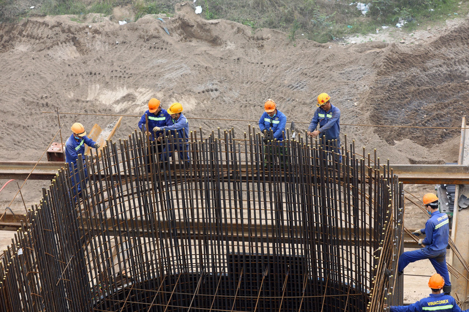 Công nhân đang thi công trụ cầu dẫn bên phía quận Long Biên. (Ảnh: Huy Hùng/TTXVN)