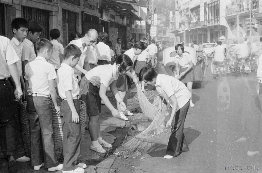 Thanh thiếu niên Sài Gòn làm vệ sinh đường phố sau ngày giải phóng (1975). (Ảnh: Vũ Tạo/TTXVN)