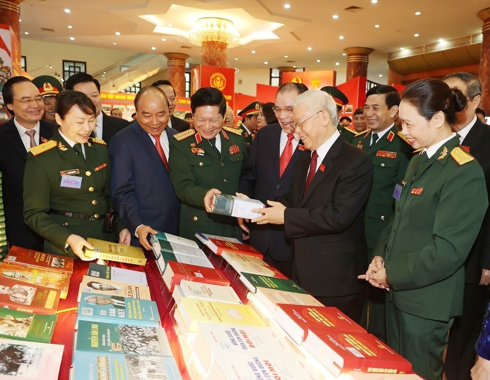 Tổng Bí thư, Chủ tịch nước, Bí thư Quân ủy Trung ương Nguyễn Phú Trọng và các đại biểu thăm gian trưng bày các ấn phẩm quốc phòng. (Ảnh: Trí Dũng/TTXVN)