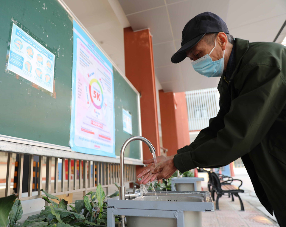 Khu vực rửa tay để học sinh trường THPT Trương Định, quận Hoàng Mai sử dụng khi đi học lại được lắp đặt thêm bảng thông điệp tuyên truyền về phòng, chống dịch COVID-19 (ảnh chụp sáng 5/12). (Ảnh: Thanh Tùng/TTXVN)