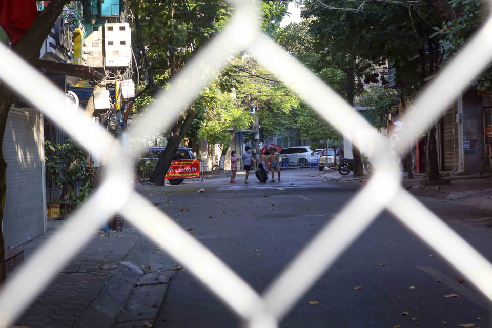 Người dân bên trong khu vực cách ly tại phố Vũ Hữu Lợi (phường Nguyễn Du, quận Hai Bà Trưng). (Ảnh: Tuấn Đức/TTXVN)