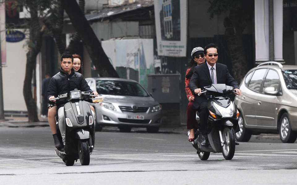 Đi xe máy không đội mũ bảo hiểm trên phố Hàng Bài. (Ảnh: Minh Đức/TTXVN)