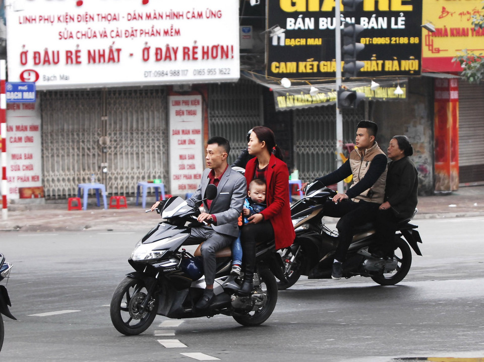 Người dân tham gia giao thông không đội mũ bảo hiểm trên phố Bạch Mai. (Ảnh: Minh Đức/TTXVN)