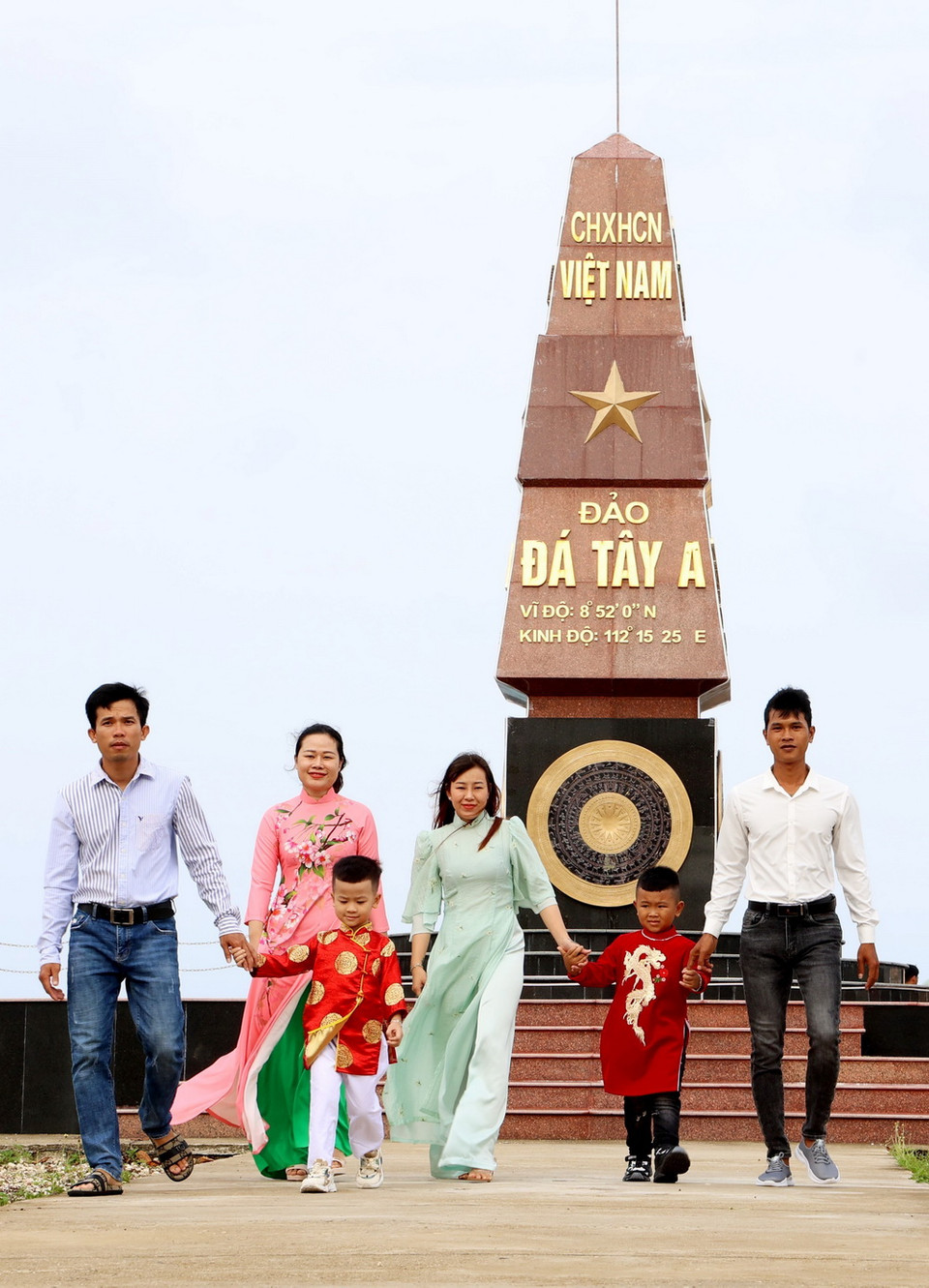 Người dân đảo Đá Tây dưới Cột mốc chủ quyền. (Ảnh: Hồng Đạt/TTXVN)