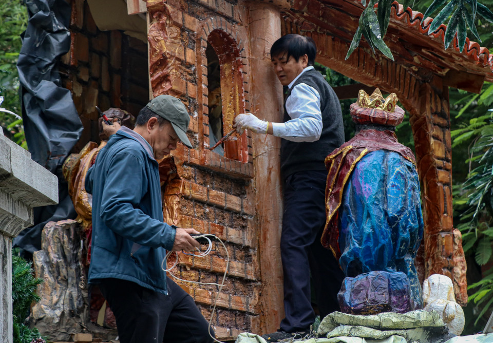 Những người thợ đang hoàn thành nốt các phần việc còn lại của tiểu cảnh. (Ảnh: Minh Hiếu/Vietnam+)