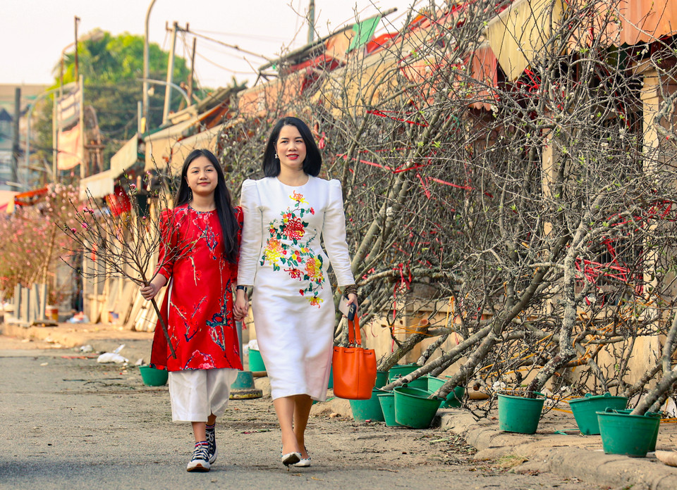 Không chỉ đến đây mua đào, nhiều người dân còn tranh thủ đến đây chụp ảnh lưu niệm, lưu lại những khoảnh khắc với sắc đào đầu mùa. (Ảnh: Minh Hiếu/Vietnam+)