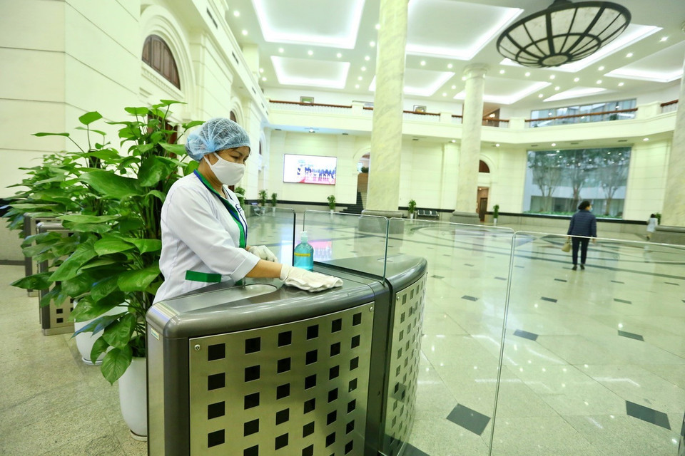 Nhân viên Văn phòng Bộ Tài chính thường xuyên thực hiện vệ sinh sát khuẩn 1 lần/giờ tại các bề mặt có nhiều người tiếp xúc. (Ảnh: Minh Quyết/TTXVN)