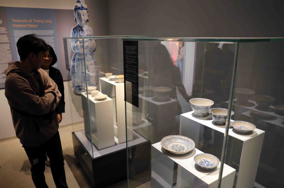 Khách tham quan chiêm ngưỡng bộ sưu tập bát, đĩa gốm hoa lam ngự dụng thời Lê sơ, niên đại thế kỷ 15-đầu thế kỷ 16; hiện lưu giữ tại Trung tâm Bảo tồn Di sản Thăng Long-Hà Nội. (Ảnh: Thanh Tùng/TTXVN)