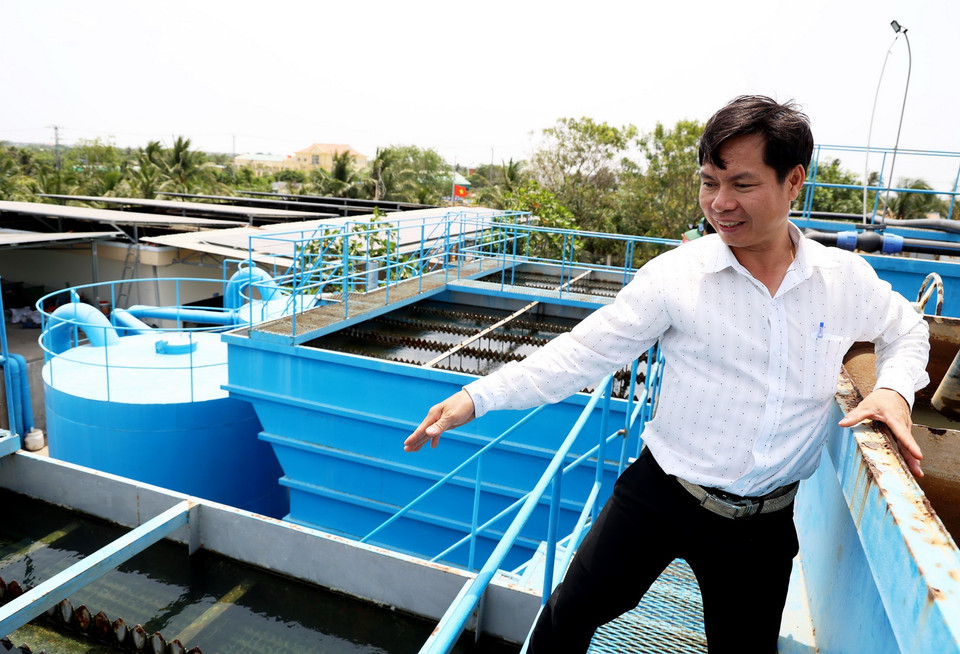 Anh Dương Hồng Vũ, cán bộ Phòng Nông nghiệp và Phát triển nông thôn huyện Ba Tri giới thiệu quy trình sản xuất nước sạch trong Nhà máy nước Kênh Lấp. (Ảnh: Hồng Đạt/TTXVN)