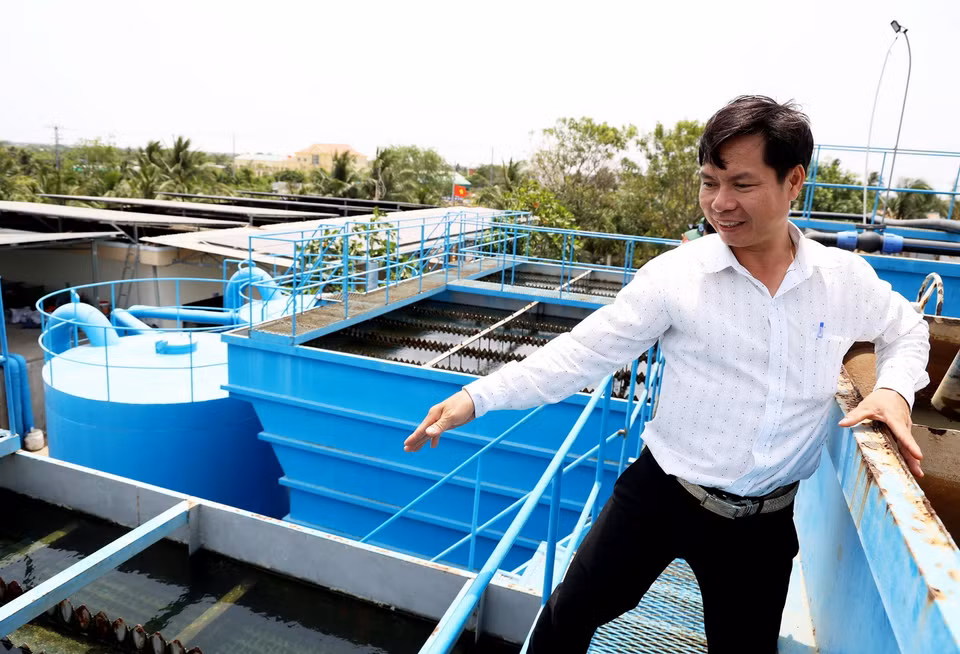 Anh Dương Hồng Vũ, cán bộ Phòng Nông nghiệp và Phát triển nông thôn huyện Ba Tri giới thiệu quy trình sản xuất nước sạch trong Nhà máy nước Kênh Lấp. (Ảnh: Hồng Đạt/TTXVN)