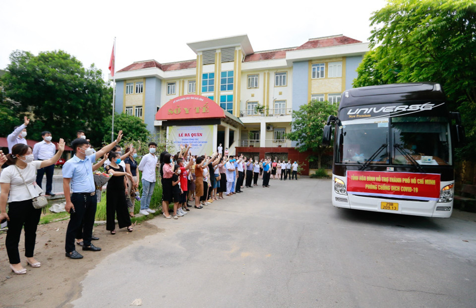 Cán bộ và nhân dân tỉnh Hòa Bình chào tạm biệt và gửi tinh thần quyết thắng khi xe chở đoàn cán bộ y tế lăn bánh xuất phát vào chi viện cho Thành phố Hồ Chí Minh trong cuộc chiến chống dịch COVID-19. (Ảnh: Trọng Đạt/TTXVN)