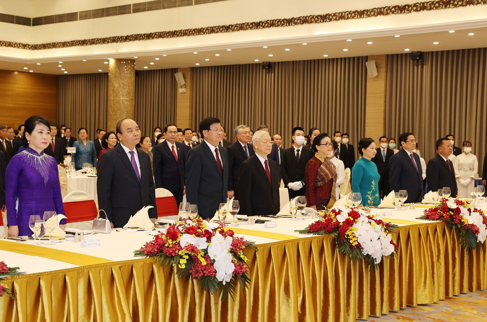 Tổng Bí thư Nguyễn Phú Trọng và Phu nhân, Chủ tịch nước Nguyễn Xuân Phúc và Phu nhân, Tổng Bí thư, Chủ tịch nước Lào Thongloun Sisoulith và Phu nhân cùng các đại biểu thực hiện nghi lễ chào cờ. (Ảnh: Trí Dũng/TTXVN)