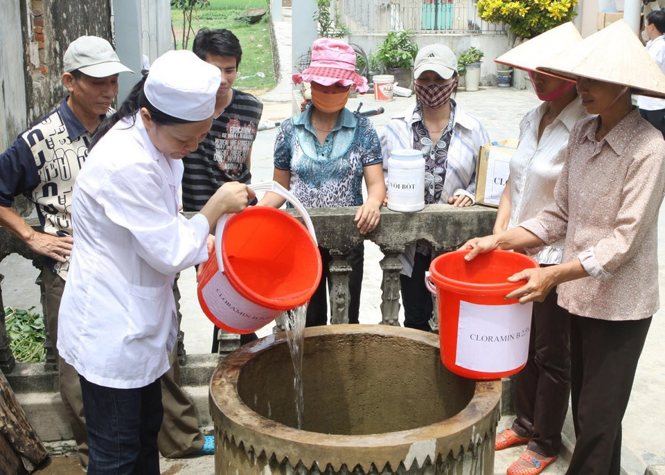 Lĩnh vực y tế phát triển mạnh mẽ, đạt nhiều thành tựu trong suốt những năm Đổi mới. Trong ảnh: Cán bộ y tế xã Đức Long hướng dẫn người dân khử trùng nguồn nước sinh hoạt trước mùa mưa bão. (Ảnh: Dương Ngọc/TTXVN)