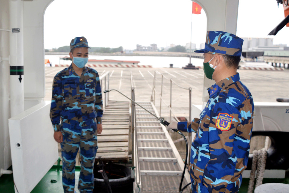 Phun thuốc khử trùng trước khi lên tàu. (Ảnh: TTXVN phát)