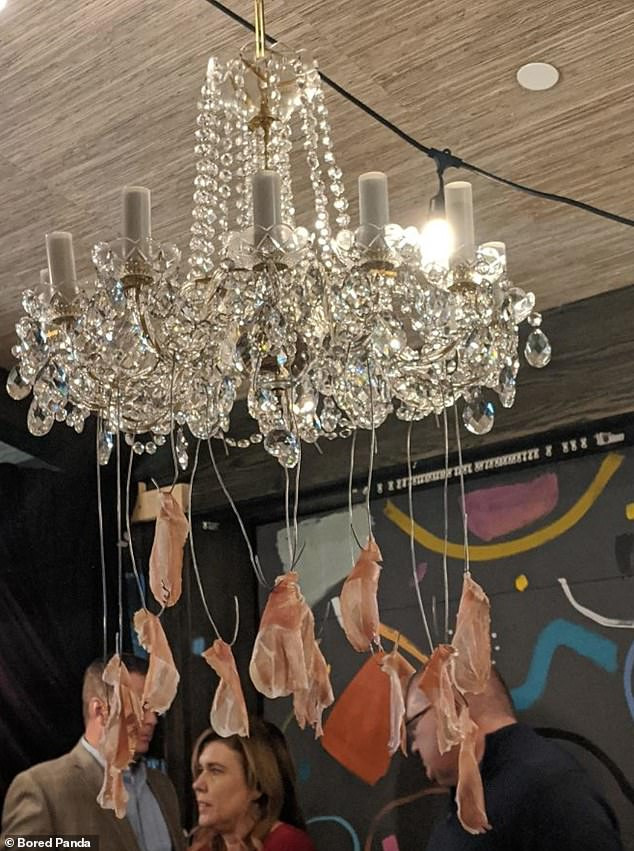 Những miếng thịt xông khói được treo dưới chiếc đèn pha lê, gợi đến cách người xưa treo những miếng thịt rồi hong trên khói. (Nguồn: Daily Mail)