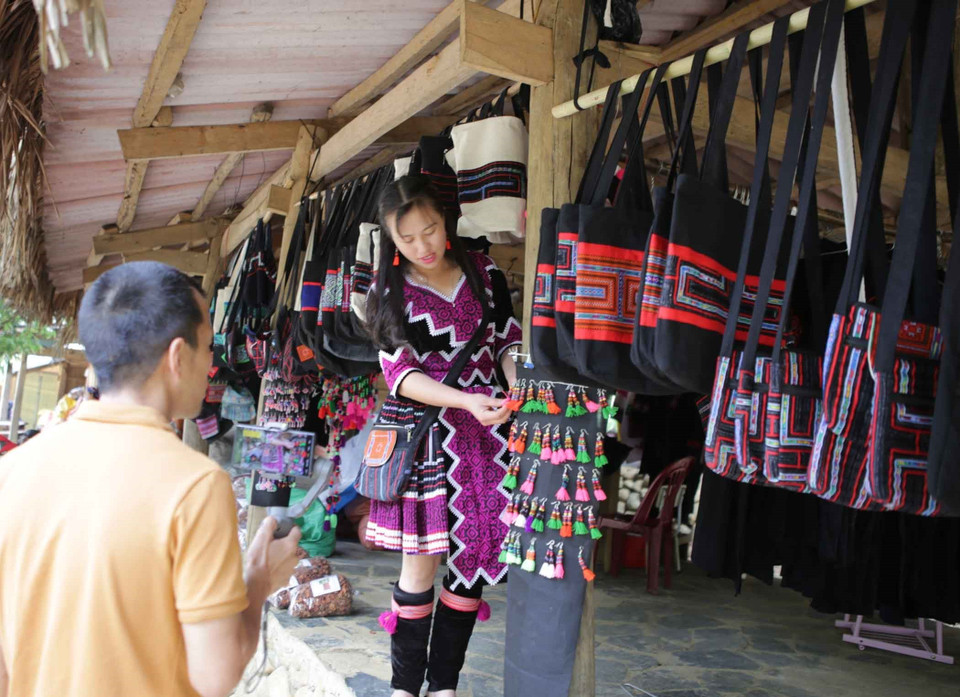 Du khách lựa chọn sản phẩm thêu dệt thủ công làm quà lưu niệm tại chợ phiên Sin Suối Hồ. (Ảnh: Quý Trung/TTXVN)