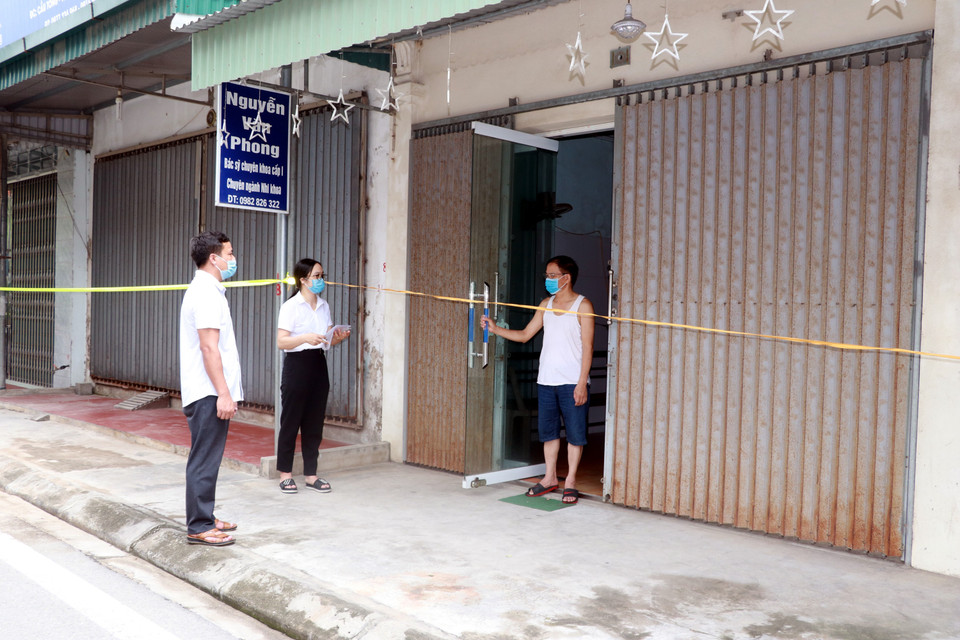 Cán bộ tổ COVID-19 cộng đồng xã Yên Thắng, huyện Ý Yên đến từng nhà rà soát, kiểm tra sức khỏe và ghi nhận yêu cầu đăng ký mua sắm hàng hóa, nhu yếu phẩm cho người dân khu vực phong tỏa. (Ảnh: Nguyễn Lành/TTXVN)