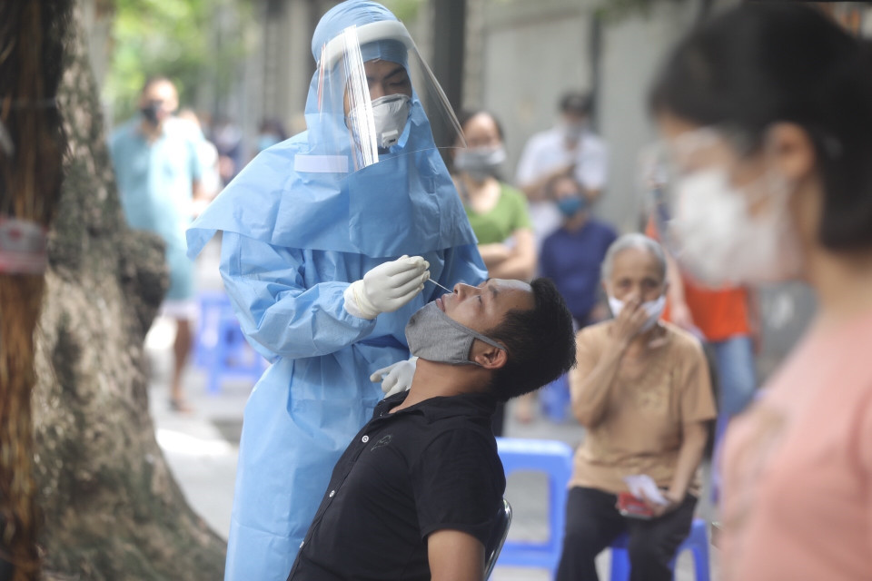 Nhân viên y tế lấy mẫu xét nghiệm cho người dân tổ dân phố số 1, tại số 157 phố Bà Triệu. (Ảnh: Minh Quyết/TTXVN)