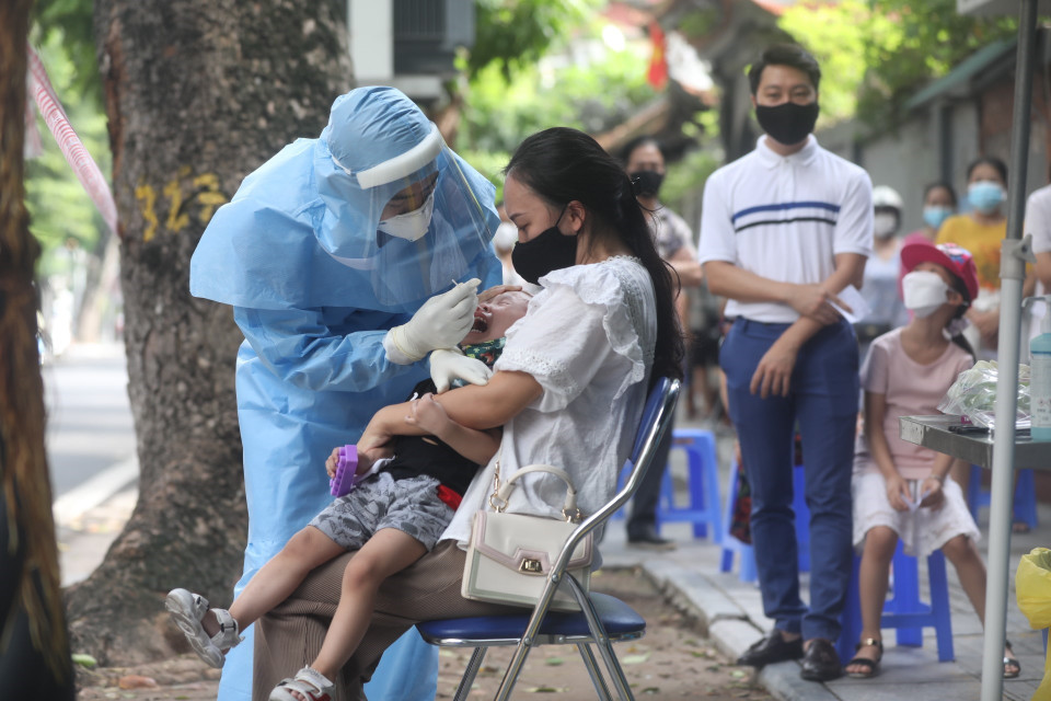 Nhân viên y tế lấy mẫu xét nghiệm cho người dân tổ dân phố số 1, tại số 157 phố Bà Triệu. (Ảnh: Minh Quyết/TTXVN)