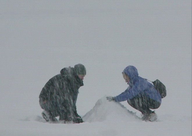 Hai bạn trẻ đang đắp ông già tuyết. (Ảnh: Thanh Tuấn/Vietnam+)