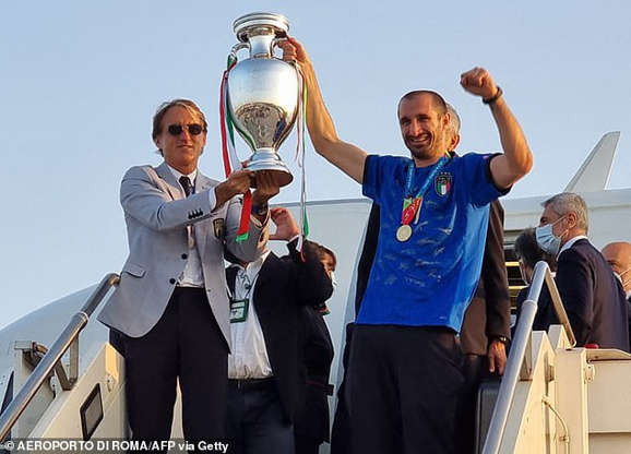 Huấn luyện viên Roberto Mancini cùng thủ quân Giorgio Chiellini nâng cao chiếc cúp khi về đến Rome. (Nguồn: Getty Images)