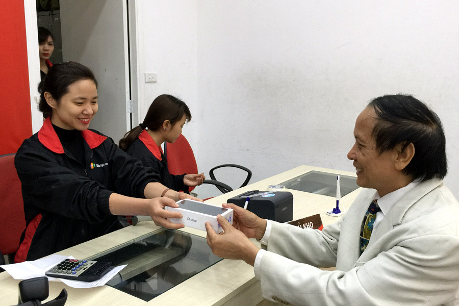 Bác Trần Long, 70 tuổi là một trong những khách hàng nhận máy sớm nhất tại FPT Shop Thái Hà. (Ảnh: T.H/Vietnam+)