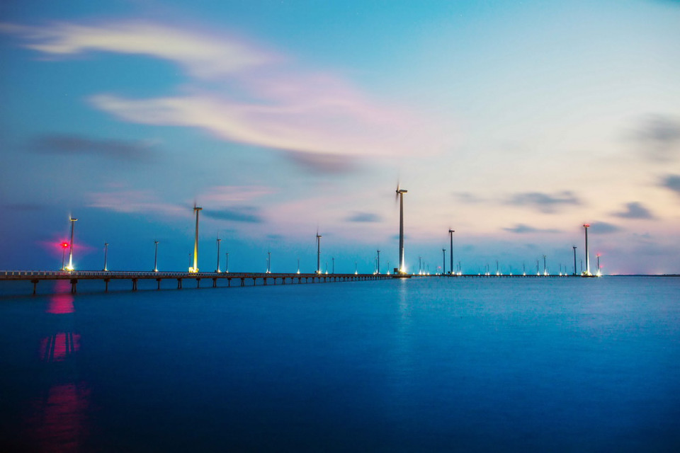 Nhà máy điện gió mới được hoàn thành với hàng trăm cánh quạt gió, nhìn từ xa khoảng chục cây số, chúng ta đã có thể thấy những trụ turbine lắp cánh quạt quay đều như những chong chóng khổng lồ in trên nền trời. (Ảnh: Trọng Đạt/TTXVN)