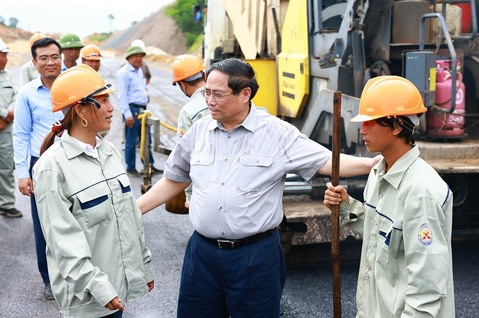 Thủ tướng Phạm Minh Chính thăm hỏi, động viên công nhân thi công Dự án xây dựng tuyến đường Đông-Tây. (Ảnh: Dương Giang/TTXVN)
