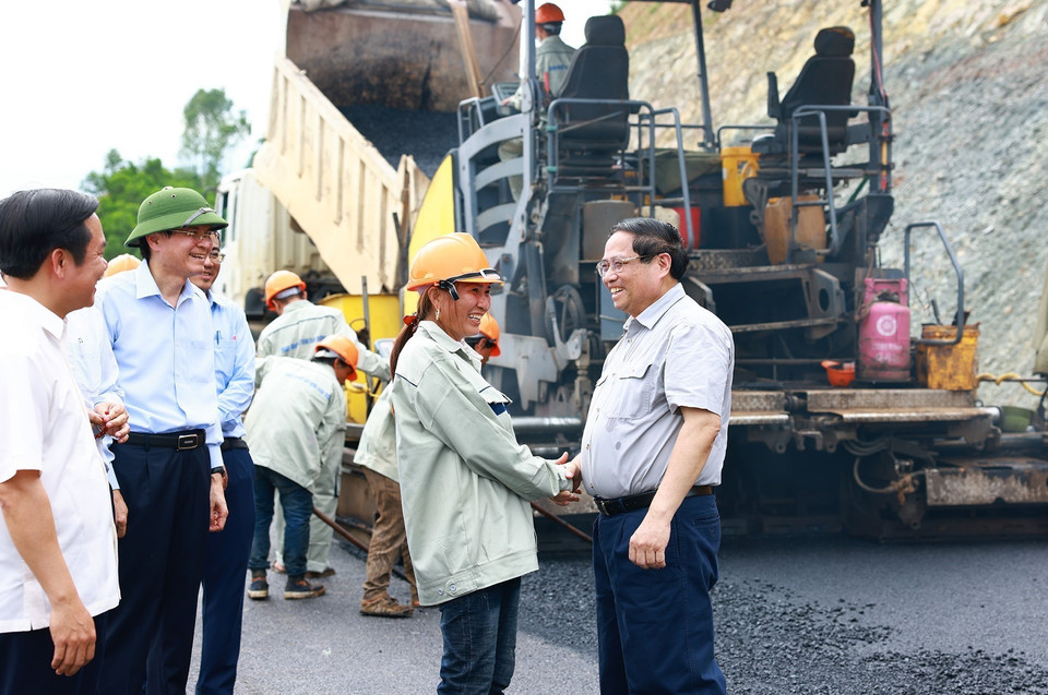 Thủ tướng Phạm Minh Chính thăm hỏi, động viên công nhân thi công Dự án xây dựng tuyến đường Đông-Tây. (Ảnh: Dương Giang/TTXVN)