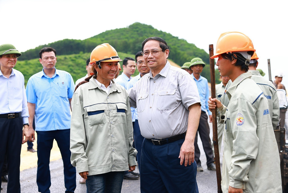 Thủ tướng Phạm Minh Chính thăm hỏi, động viên công nhân thi công Dự án xây dựng tuyến đường Đông-Tây. (Ảnh: Dương Giang/TTXVN)