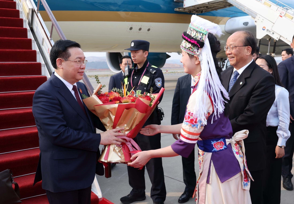 Thiếu nữ tỉnh Vân Nam tặng hoa chào đón Chủ tịch Quốc hội Vương Đình Huệ và Đoàn đại biểu cấp cao Việt Nam tại Sân bay quốc tế Trường Thủy Côn Minh. (Ảnh: Nhan Sáng/TTXVN)