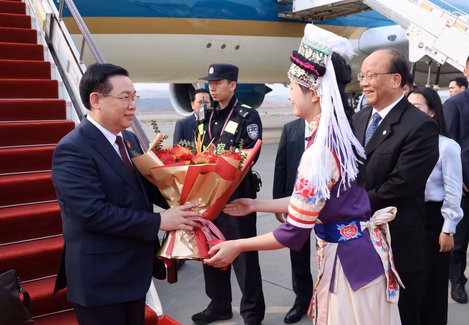 Thiếu nữ tỉnh Vân Nam tặng hoa chào đón Chủ tịch Quốc hội Vương Đình Huệ và Đoàn đại biểu cấp cao Việt Nam tại Sân bay quốc tế Trường Thủy Côn Minh. (Ảnh: Nhan Sáng/TTXVN)