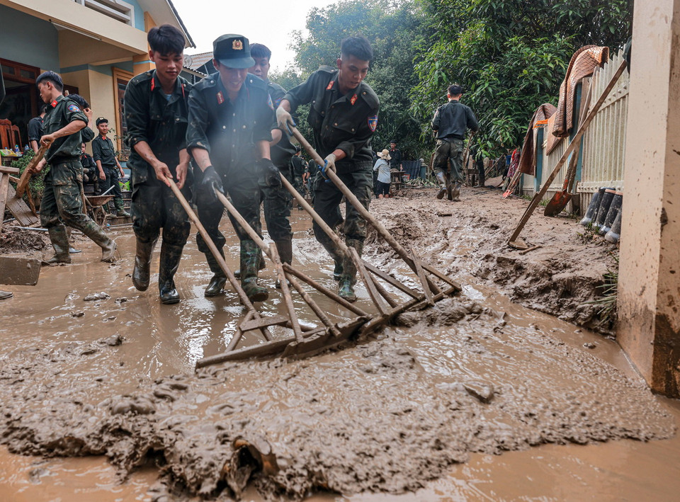 Cảnh sát cơ động dọn dẹp bùn đất, nhà cửa cho người dân xã Phúc Khánh, huyện Bảo Yên, tỉnh Lào Cai. (Ảnh: Hoàng Hiếu/TTXVN)