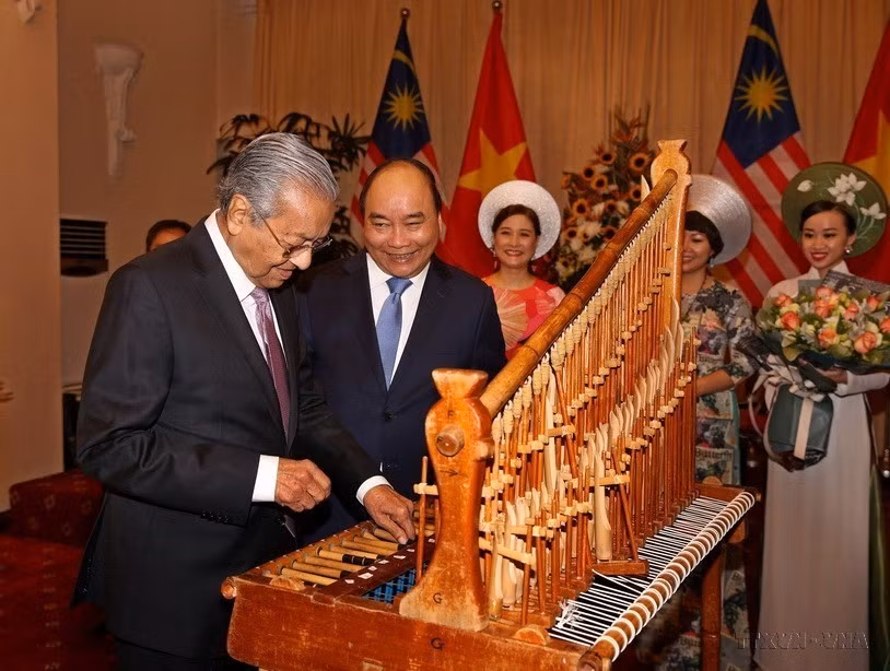 Thủ tướng Malaysia Mahathir Mohamad đánh thử nhạc cụ truyền thống dân tộc Việt Nam trong chuyến thăm chính thức Việt Nam (27/8/2019). (Ảnh: Dương Giang/TTXVN)