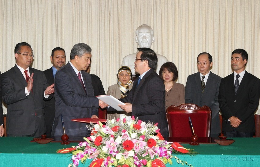 Trưởng ban đối ngoại Trung ương Đảng Hoàng Bình Quân vài Phó Chủ tịch UMNO kiêm Bộ trưởng Bộ Nội vụ Malaysia Dato’ Seri Dr. Ahmad Zahid Hamidi ký Biên bản ghi nhớ giữa Đảng Cộng sản Việt Nam và Đảng UMNO Malaysia (15/5/2014). (Ảnh: Phương Hoa/TTXVN)