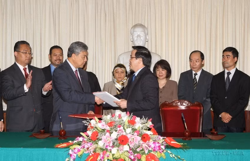 Trưởng ban đối ngoại Trung ương Đảng Hoàng Bình Quân vài Phó Chủ tịch UMNO kiêm Bộ trưởng Bộ Nội vụ Malaysia Dato’ Seri Dr. Ahmad Zahid Hamidi ký Biên bản ghi nhớ giữa Đảng Cộng sản Việt Nam và Đảng UMNO Malaysia (15/5/2014). (Ảnh: Phương Hoa/TTXVN)