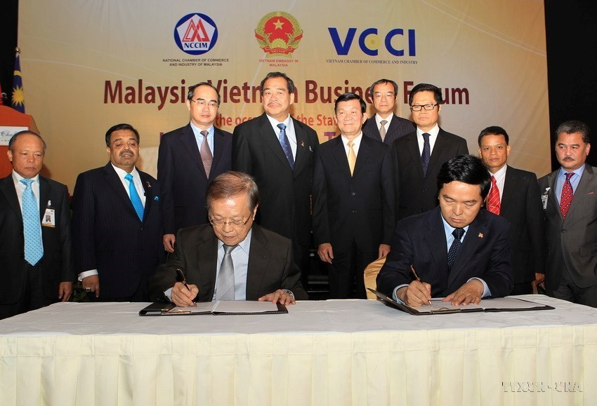 Chủ tịch nước Trương Tấn Sang chứng kiến lễ ký các hợp đồng kinh tế giữa doanh nghiệp hai nước tại Diễn đàn doanh nghiệp Việt Nam-Malaysia (29/9/2011).(Ảnh: Nguyễn Khang /TTXVN)