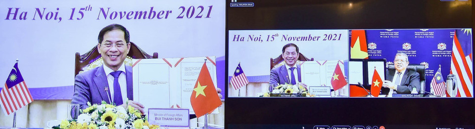 Bộ trưởng Ngoại giao Bùi Thanh Sơn và Bộ trưởng Ngoại giao Malaysia Saifuddin Abdullah ký biên bản Kỳ họp lần thứ sáu Ủy ban Hợp tác về kinh tế, khoa học và kỹ thuật Việt Nam-Malaysia theo hình thức trực tuyến (15/11/2021). (Ảnh: TTXVN)