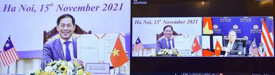 Bộ trưởng Ngoại giao Bùi Thanh Sơn và Bộ trưởng Ngoại giao Malaysia Saifuddin Abdullah ký biên bản Kỳ họp lần thứ sáu Ủy ban Hợp tác về kinh tế, khoa học và kỹ thuật Việt Nam-Malaysia theo hình thức trực tuyến (15/11/2021). (Ảnh: TTXVN)