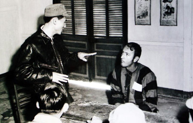 Thượng úy phi công Phạm Tuân nói chuyện với một phi công B-52 của Mỹ bị bắt trong trại giam. (Ảnh: Tư liệu/TTXVN)