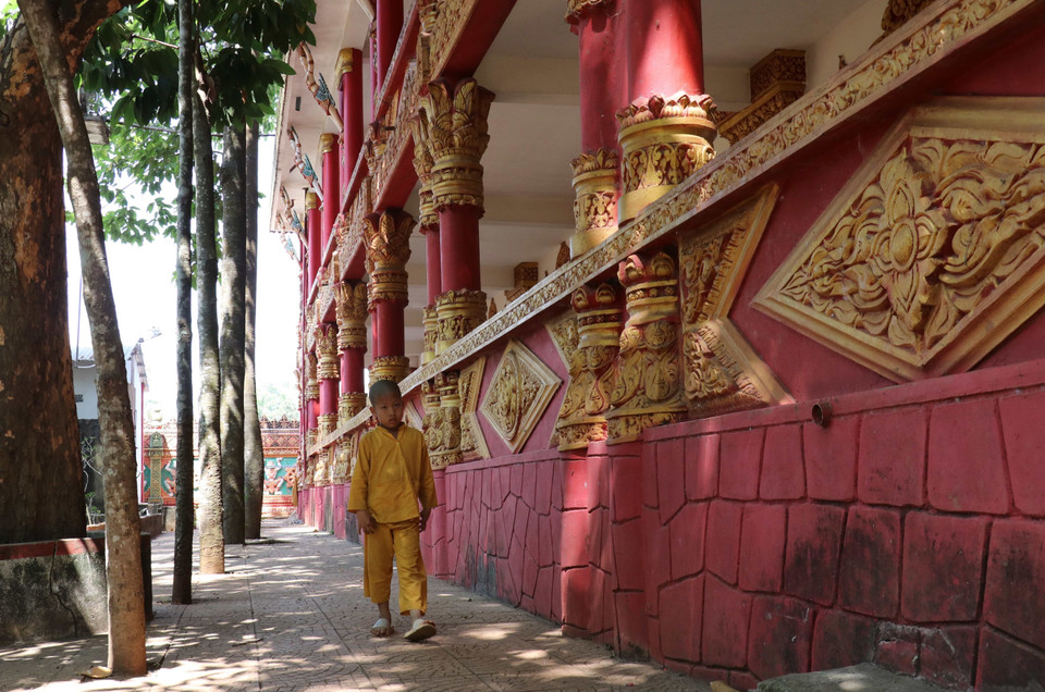 Một chú tiểu đi bộ dưới mái hiên chùa Sóc Lớn. (Ảnh: Sỹ Tuyên/TTXVN)