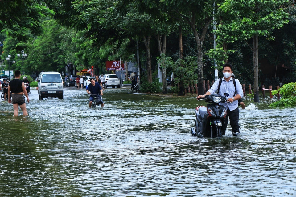 Người dân vẫn phải lội nước qua đoạn đường hồ Văn Quán, quận Hà Đông. (Ảnh: Tuấn Anh/TTXVN)