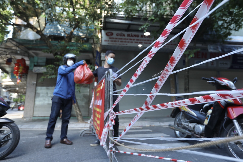 Hà Nội những ngày thực hiện giãn cách xã hội không còn xa lạ với hình ảnh các tuyến phố cổ được dựng hàng rào cứng trước lối ra, vào và giăng dây chằng chịt. (Ảnh: Minh Quyết/TTXVN)