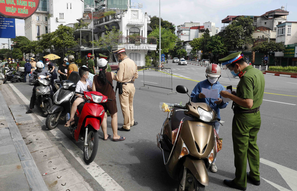 Kiểm tra giấy tờ người tham gia giao thông tại chốt kiểm soát trên phố Nguyễn Thái Học. (Ảnh: Trần Việt/TTXVN)