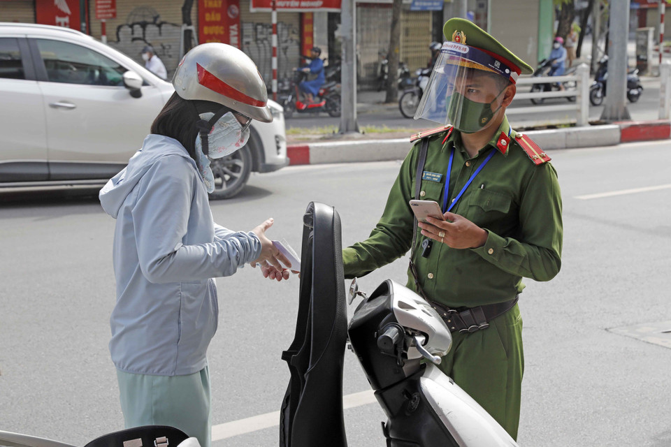 Lực lượng chức năng kiểm tra giấy tờ người tham gia giao thông tại chốt kiểm soát trên phố Điện Biên Phủ. (Ảnh: Trần Việt/TTXVN)