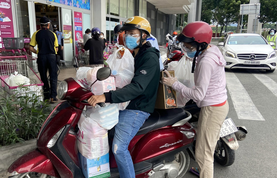 Xe máy người dân chất đầy thực phẩm sau khi mua từ Trung tâm thương mại Aeon Mall Tân Phú. (Ảnh: Mạnh Linh/TTXVN)