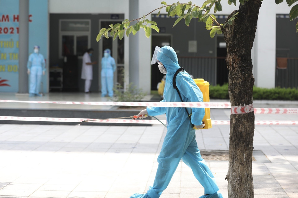 Ngay sau khi lấy mẫu xong, nhân viên y tế sẽ phun khử khuẩn luồng đi, đảm bảo quy định về phòng, chống dịch. (Ảnh: Minh Quyết/TTXVN)