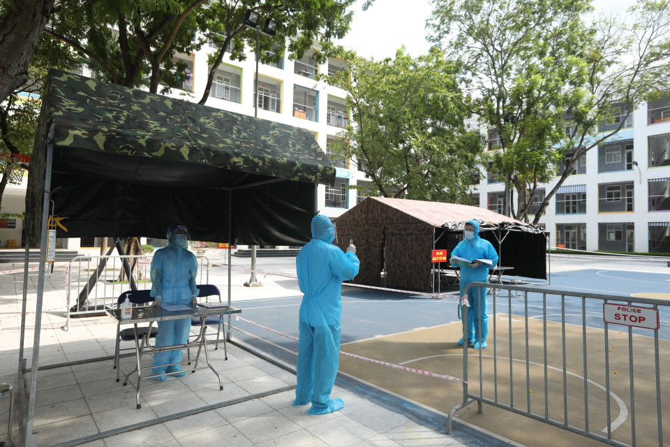 Nhân viên trực bên trong khu cách ly báo cáo với Chỉ huy trưởng về công tác quản lý, giám sát các trường hợp thực hiện cách ly tại điểm cách ly tập trung, trường Tiểu học Phú Thượng, quận Tây Hồ. (Ảnh: Minh Quyết/TTXVN)